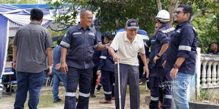 Seorang karyawan PT Timah Tbk saat membantu seorang lansia yang sedang berjalan di Dusun IV Ranggam, Desa Belo Laut, yang saat ini berstatus terlantar dan memiliki riwayat penyakit serius.(Foto/Ist)