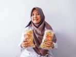 Novika, Owner Kerupuk Kulit Sapi WanMiq saat menunjukkan produk hasil buatannya yang kini sukses ia jalani setelah menjadi mitra binaan PT Timah Tbk, Jumat (28/11/2025).(Foto/Ist)